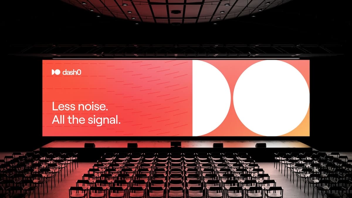 A conference stage with a wide screen showing a red-orange gradient and the Dash0 branding